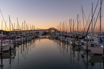 Fototapeta na wymiar A sunset shot of a marina with the Auckland Harbour bridge on the background