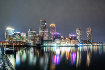 The Boston skyline and Fort Point Channel at night from Fan Pier Park
