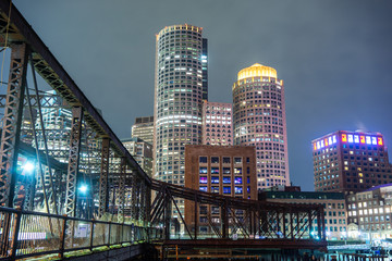 The Boston skyline and Fort Point Channel at night from Fan Pier Park