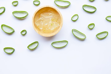 Aloe vera slices with aloe vera gel in wooden bowl on white