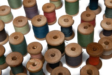 wooden coils with colorful threads of pastel colors