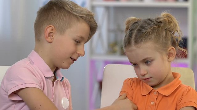 Brother apologizing to younger sister, touching her nose, reconciliation