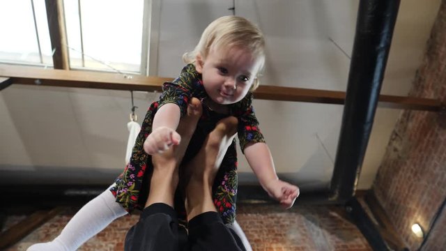Acro yoga studio father practice a pose with his little child baby daughter