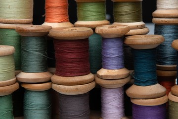 wooden coils with colorful threads of pastel colors