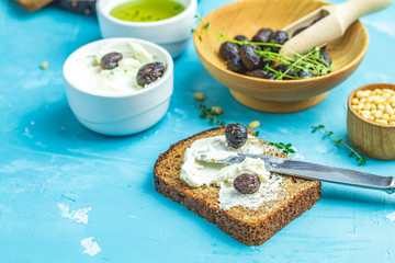 Cream Cheese on a slice of bread topped and dried olives