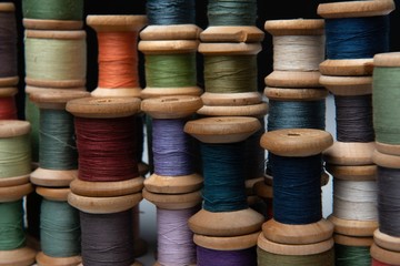 wooden coils with colorful threads of pastel colors