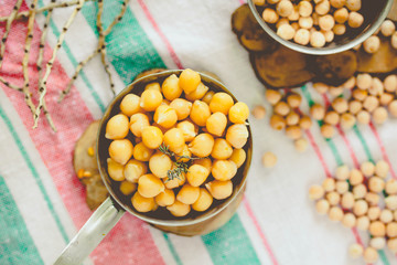 Chickpeas dry and boiled in an iron bowl, thyme. Rustik style background. Top view. Kinfolk and comfort food atmosphere concept.Toning.