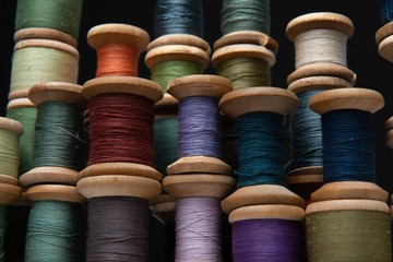 wooden coils with colorful threads of pastel colors