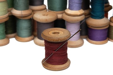 wooden coils with colorful threads of pastel colors