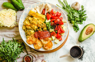 Green fresh salad with tomatoes, pink lentil mashed potatoes, baked potato slices with homemade ketchup.Vegetarian colorful lunch. Top view.