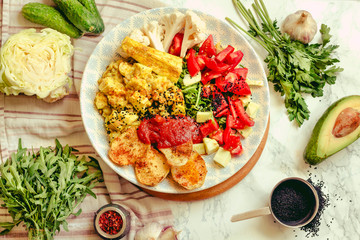 Green fresh salad with tomatoes, pink lentil mashed potatoes, baked potato slices with homemade ketchup.A large plate of healthy food for dinner.Top view.