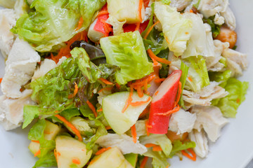 Healthy food for loose weight high fiber and vitamins. Chicken breast salad (Green apple, carrot, vegetables) in white bowl on wooden table served in dinner. 