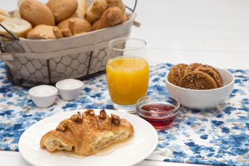 Continental breakfast with fresh croissants, biscuits, bread, jam and orange juice on table