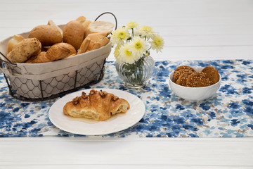 Continental breakfast with fresh croissants, bread and biscuits on table