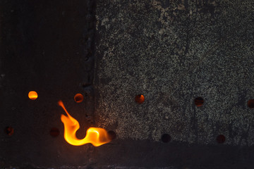 A fragment of a wall of a metal brazier with ventilation openings