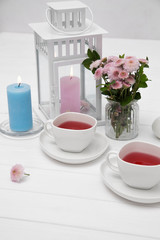 cups of fruit tea on wooden table decorated with flowers