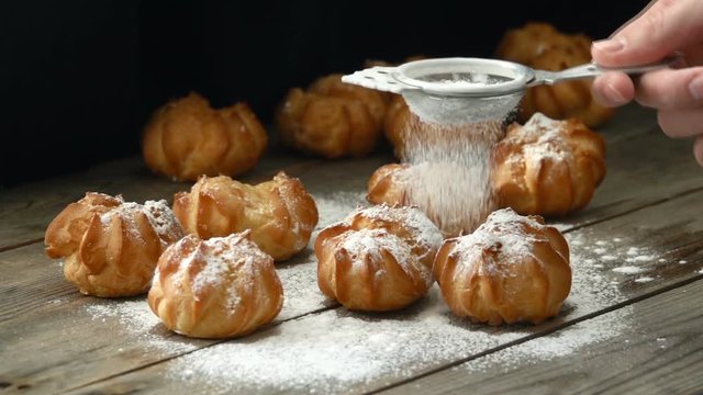 Sprinkling sugar powder over profiterole. Seamless cinemagraph video