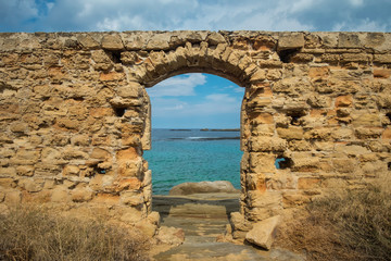 The doorway of an old ruined stone greek building with a view to the mediterranean sea at the coast of Northern Cyprus