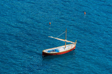 Small wooden boat with sail in the sea - Italy