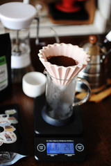 Fototapeta na wymiar Alternative coffee brewing. Pink ceramic origami dripper. Coffee grinder. Gooseneck kettle. Electronic scale