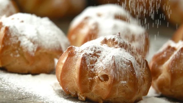 Sprinkling sugar powder over profiterole. Seamless cinemagraph video