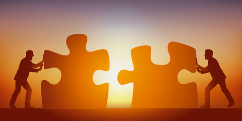 Concept du partenariat pour trouver une solution à un problème, avec deux hommes qui mettent en commun leurs intelligences, symbolisé par deux pièces de puzzle. - obrazy, fototapety, plakaty