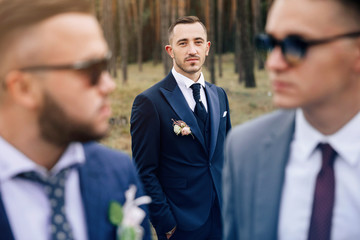 Stylish groom. Stylish portrait groomsmen and groom stand on nature.