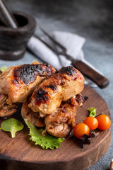Baked boneless chicken thighs on board, closeup shot