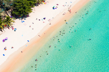 Fototapeta na wymiar View from above, aerial view of a beautiful tropical beach with white sand, turquoise clear water and people sunbathing, Surin beach, Phuket, Thailand.