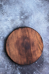 Round cutting board on a grunge background top view with copy space