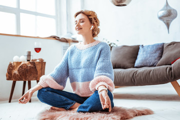 Beautiful nice woman practicing yoga at home