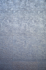 Glossy relief cladding tiles on wall closeup