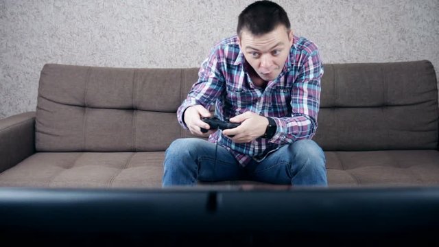 Stressed depressed young man playing gaming on pad