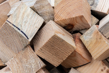 A pile of wooden cubes of pine, waste wood production. Raw materials for the manufacture of sawdust and shavings. Close-up