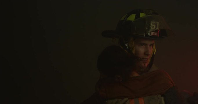 Firefighter carrying woman off frame - slow motion