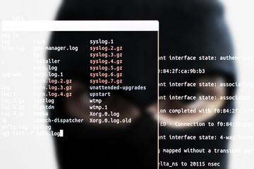 Man with balaclava, blurred with lines of software and overlapping linux shell. Concept to define the problems of cyber security and cyber crimes. Hackering a network