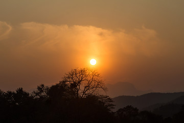View of the sun setting down behind the mountains.