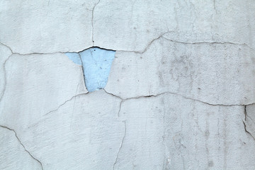 Gray-blue concrete wall, covered with cracks in the plaster reminiscent of a map of the world with the borders of States