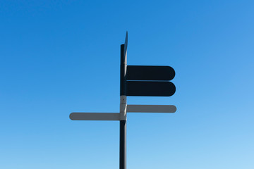 Pole with foure blank signposts to fill in text on a blue sky background