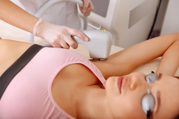 Naklejka premium Professional depilatory master making photo hair removal from armpits