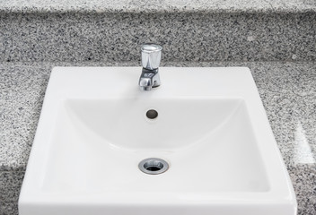 White sink basin on the marble counter.