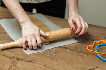 close up of female hands making cookies from fresh dough at home