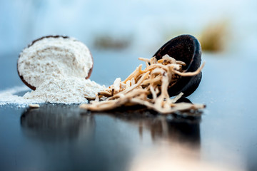 Popular Indian & Asian ayurvedic organic herb musli Safed Moosli/ Shaqaqule/ Dholi Musli/ Khiruva/ Shedheveli/ Swetha Musli/ Taniravi Thang/ in a clay bowl on wooden surface with its powder also.