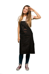 Full body Young woman with apron saluting with hand on isolated background