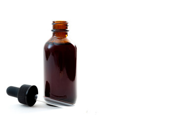 Homeopathic remedy and liquid tincture medicines concept with close up on a brown medicine glass...