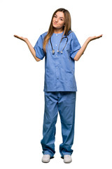 Full body Young nurse making unimportant gesture while lifting the shoulders on isolated background