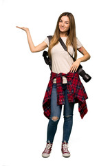 Full body Young photographer woman holding copyspace imaginary on the palm to insert an ad on isolated background