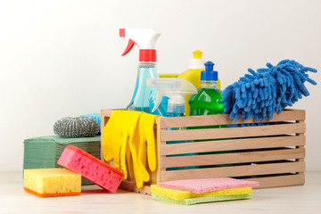 Bottles with detergent and cleaning tools in a drawer on a light background. cleaning. cleaning products.