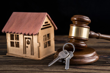 Wooden house, judge hammer, keys on wooden background. realty. lawsuit.