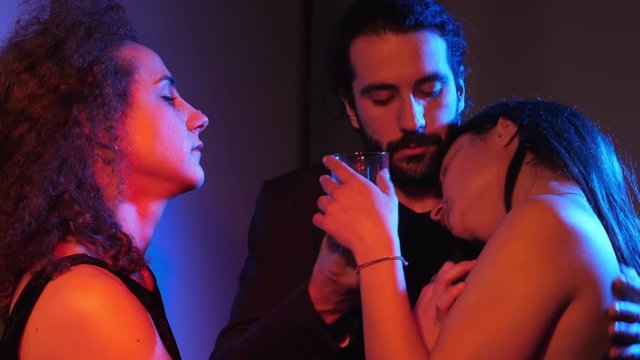three young people flirting in the dark night club.Polyamory,attraction,love